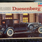 A 1/24 scale model kit box for the 'Classic Duesenberg Town Car' by Monogram. The packaging features an illustration of a black 1934 SJ Town Car with white-walled tires, set against a background of classical columns.
